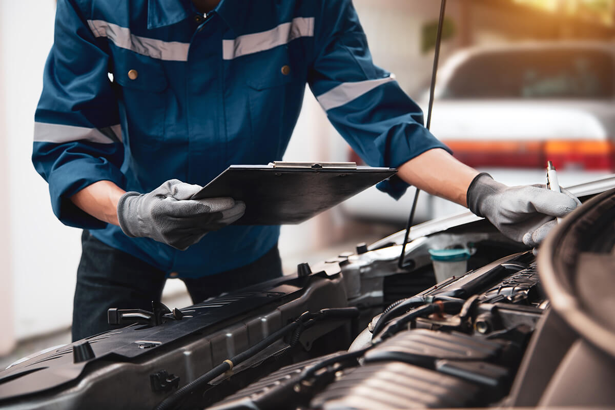 Hand technician auto mechanic checking inspection list Hand technician auto mechanic checking inspection list