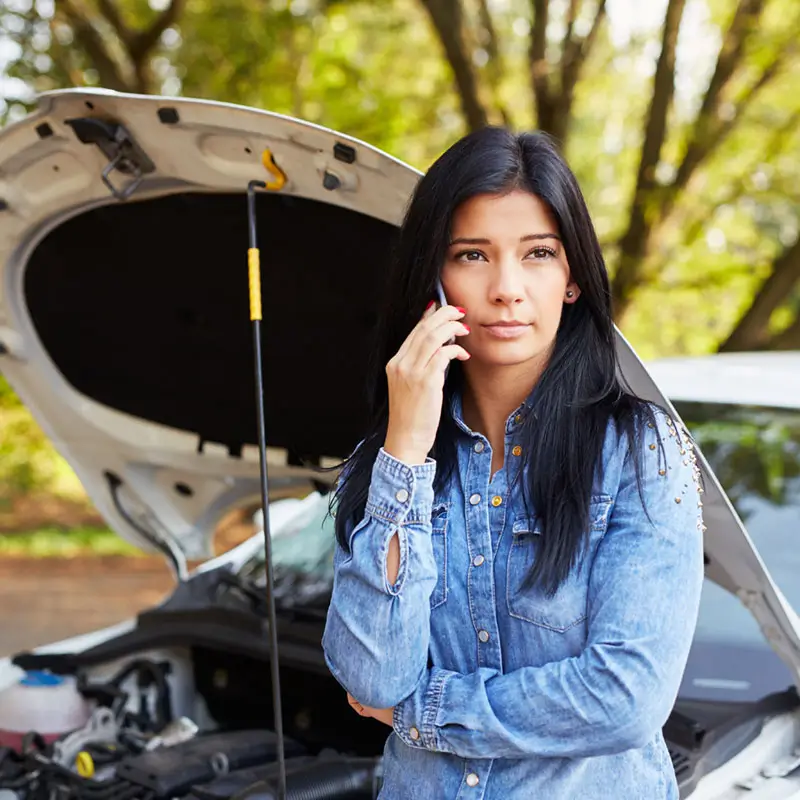 Young woman with a broken car 