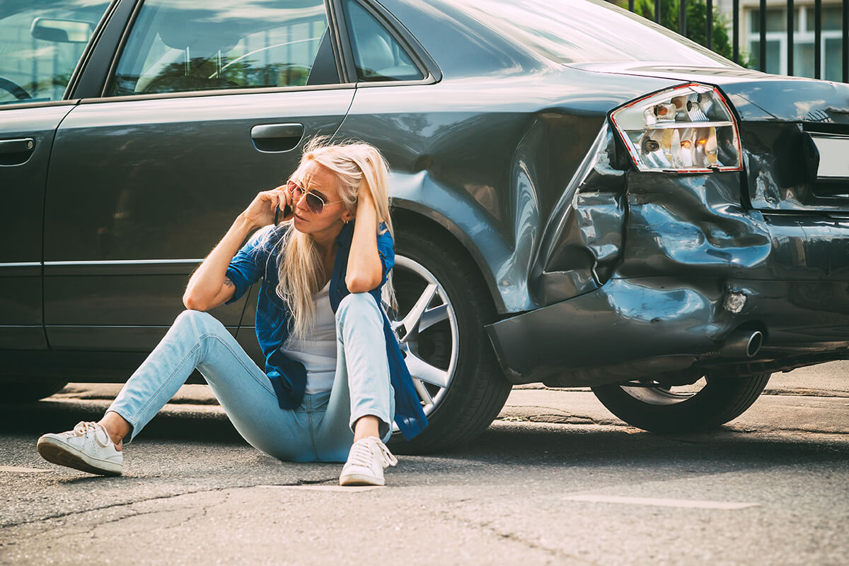 girl sits on the road, near the broken car girl sits on the road, near the broken car